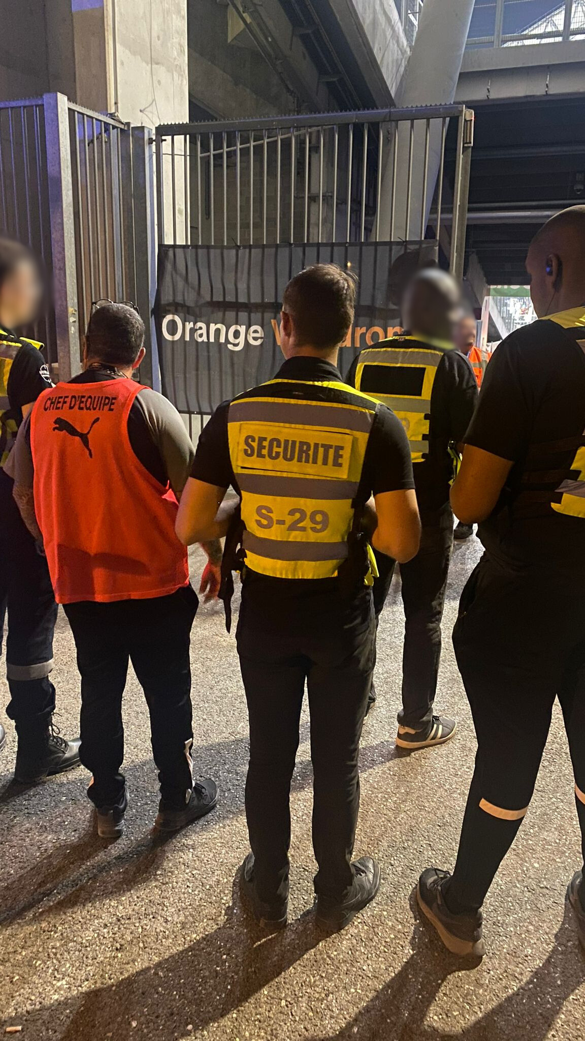 Agent de sécurité de Secu One surveillant l'entrée d'un stade pour la sécurité des spectateurs.